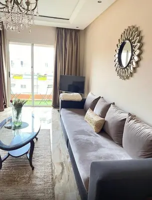 a living room with a couch and a table and a mirror at Dar Aicha in Marrakech