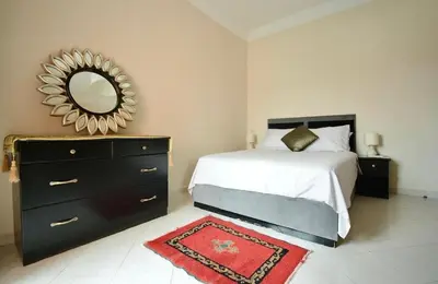 a bedroom with a bed with a mirror and a dresser at Dar Aicha in Marrakech