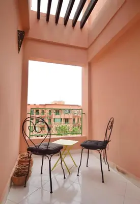 a room with two chairs and a table and a window at Dar Aicha in Marrakech