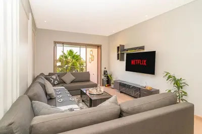a living room with a couch and a tv at Luxury 3BD Golf View Pool Fast Fiber WiFi in Marrakech