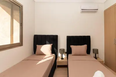 two beds sitting next to each other in a room at Luxury 3BD Golf View Pool Fast Fiber WiFi in Marrakech