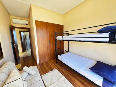 a room with two bunk beds and a couch at Jubaea Prestigia Cosy appartement avec vue sur Atlas à Marrakech in Marrakech