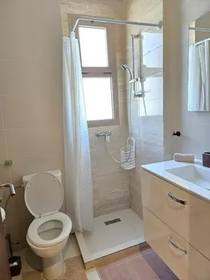 a bathroom with a toilet and a shower and a sink at Jubaea Prestigia Cosy appartement avec vue sur Atlas à Marrakech in Marrakech