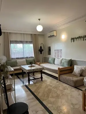 a living room with a couch and a table at Appartement spacieux 1min Menara Mall 5mins de gare ferroviaire in Marrakech