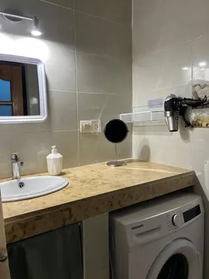 a bathroom with a sink and a washing machine at Appartement spacieux 1min Menara Mall 5mins de gare ferroviaire in Marrakech