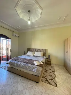 a bedroom with a large bed with a ceiling at Villa Familiale in Marrakech
