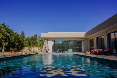 a house with a swimming pool in front of a house at MIKESTAY - Villa Sherazade in Marrakech