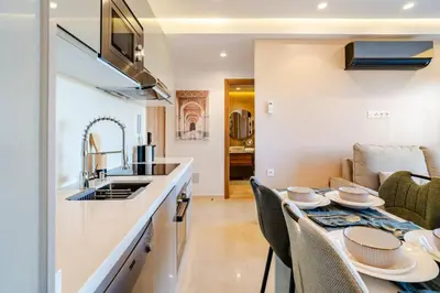 a kitchen and living room with a table and a sink at Marrakesh, Noria Residence, Luxury 1BR, Atlas View in Marrakech