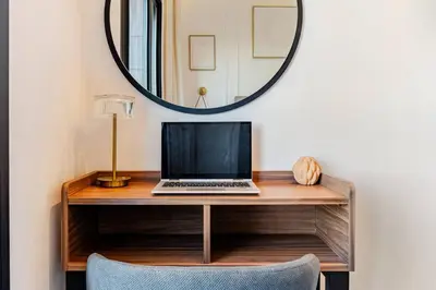 a desk with a laptop on it with a mirror at Marrakesh, Noria Residence, Luxury 1BR, Atlas View in Marrakech