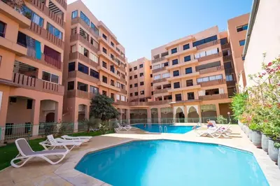 a swimming pool in front of a building at Calm Apartment with Pool in Geuliz marrakech Close to Medina in Marrakech