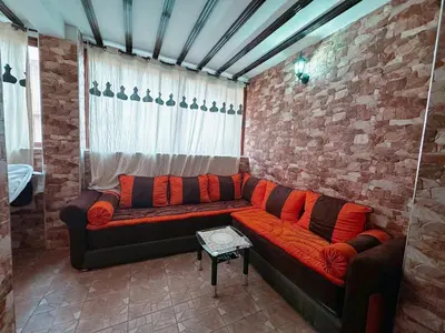 a couch in a room with a brick wall at Calm Apartment with Pool in Geuliz marrakech Close to Medina in Marrakech