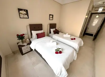 two beds in a hotel room with flowers on them at Calm Apartment with Pool in Geuliz marrakech Close to Medina in Marrakech