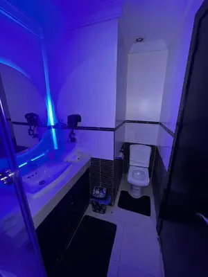 a bathroom with a white toilet and a sink at Calm Apartment with Pool in Geuliz marrakech Close to Medina in Marrakech