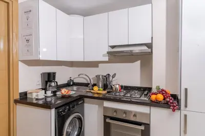 a kitchen with white cabinets and a sink and a dishwasher at Lalla Homes 369 in Marrakech