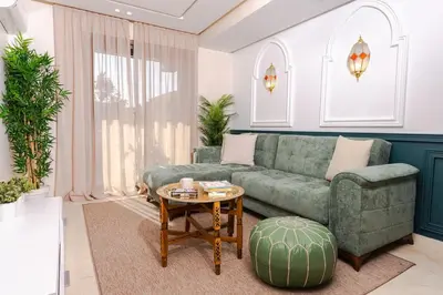 a living room with a green couch and a table at Lalla Homes 369 in Marrakech
