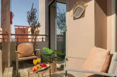 a balcony with chairs and a table with fruit on it at Lalla Homes 369 in Marrakech