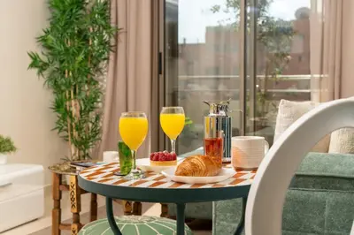 a table with a tray of food and two glasses of orange juice at Lalla Homes 369 in Marrakech
