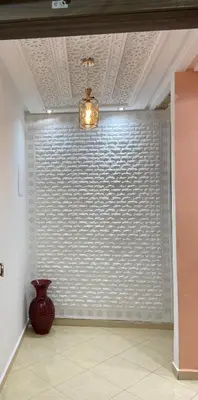 a large white wall with a vase in a room at Bech Appart Marrakech in Marrakech
