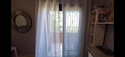 a window with a white curtain and a mirror at Atlantic Villa in Marrakech