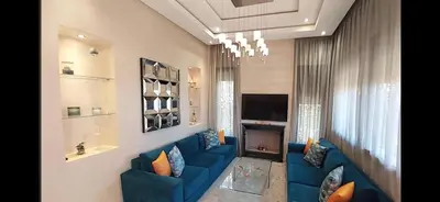 a living room with a blue couch and a fireplace at Atlantic Villa in Marrakech