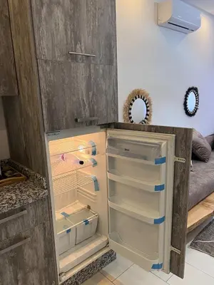 an empty refrigerator with its door open in a kitchen at Modern quiet studio Close to Guéliz in Marrakech