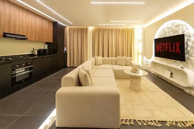 a living room with a white couch and a kitchen at Exceptional Apartment Overlooking Marrakech Train Station in Marrakech