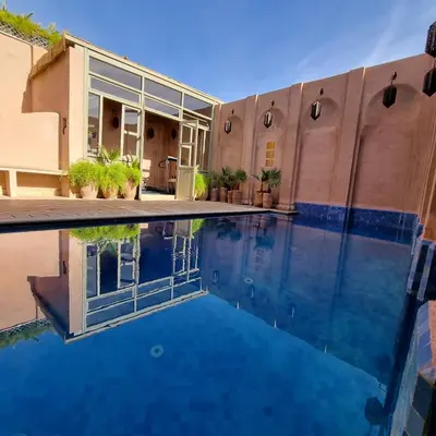 a swimming pool in front of a house at Almaha Marrakech Restaurant & SPA in Marrakech