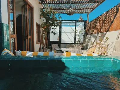 a swimming pool with a table and chairs in the water at Kasbah Djellaba pool breakfast city center in Marrakech