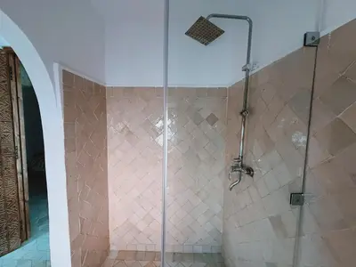 a shower with a glass door in a bathroom at Kasbah Djellaba pool breakfast city center in Marrakech