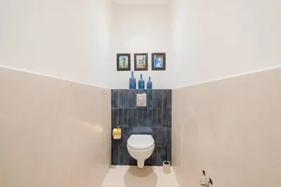 a bathroom with a toilet and three pictures on the wall at 3BR Gueliz , Rooftop Heated Pool , 10 min Jamaa el Fna, in Marrakech