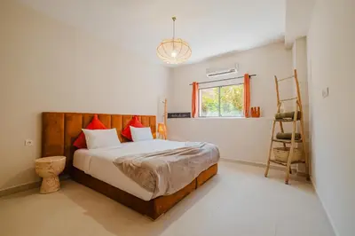 a bedroom with a bed and a window and a ladder at 3BR Gueliz , Rooftop Heated Pool , 10 min Jamaa el Fna, in Marrakech