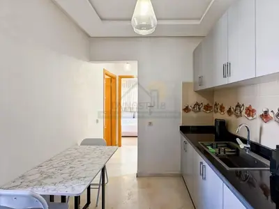 a kitchen with a table and a counter top at Appartement de charme au cœur de la ville rouge in Marrakech