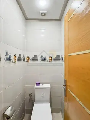 a bathroom with a toilet and a wooden door at Séjour chic au cœur de Marrakech in Marrakech