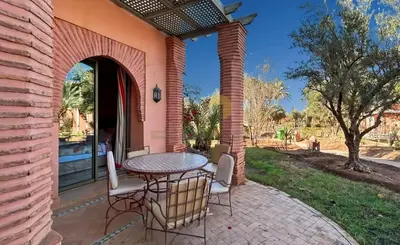a patio with a table and chairs on a patio at Evasion élégante à la Palmeraie in Marrakech
