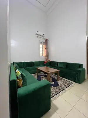 a living room with a green couch and a table at Modern Apartment & 8 min from Marrakech Airport in Marrakech
