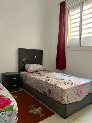 a bedroom with two beds and a window at Modern Apartment & 8 min from Marrakech Airport in Marrakech