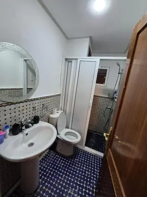 a bathroom with a sink and a toilet and a mirror at Appartement centre ville Gueliz in Marrakech