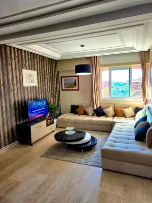 a living room with a couch and a tv at Appartement centre ville Gueliz in Marrakech