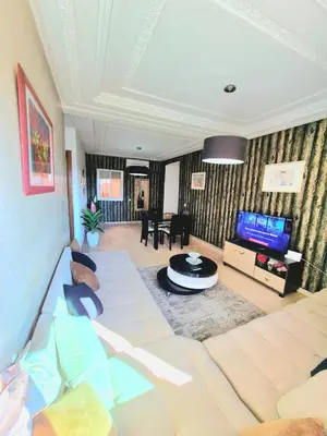 a living room with a couch and a tv at Appartement centre ville Gueliz in Marrakech