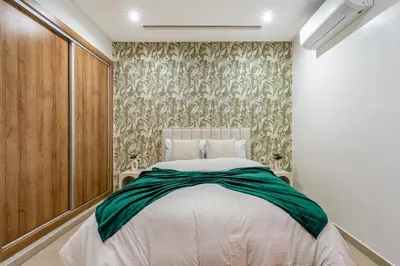 a bedroom with a white bed and a wall at Studio élégant et paisible au cœur de Marrakech in Marrakech