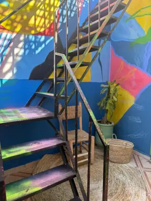 a wooden ladder in front of a colorful wall at Riad R Art in Marrakech