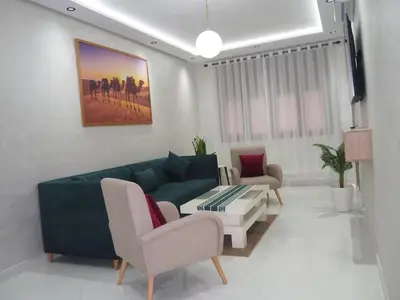 a living room with a green couch and chairs at HU Aappartement in Marrakech