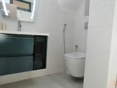 a white bathroom with a toilet and a mirror at HU Aappartement in Marrakech