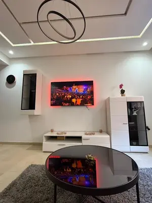a living room with a table and a tv on the wall at Luxury 2-room apartment - Pool view in Marrakech