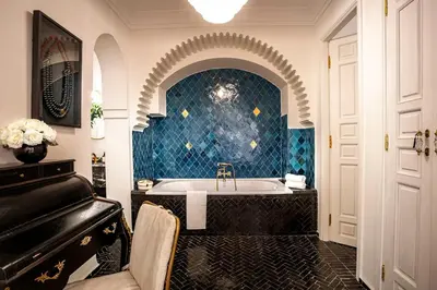 a bathroom with a tub and a piano at Riad Anaqa in Marrakech