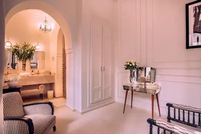 a bathroom with a sink and a chair and a table at Riad Anaqa in Marrakech