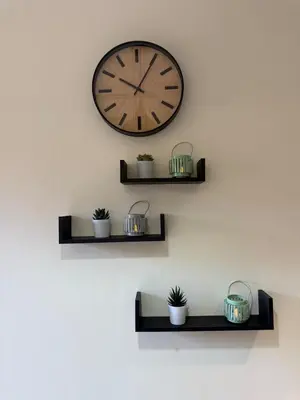 a clock hanging on a wall with some plants at Appartement Haut standing Gueliz, Piscines, jacuzzi chauffé & Fitness in Marrakech