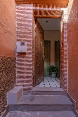 a brick hallway with a door and a plant at Riad Garden View in Marrakech