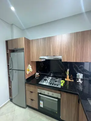 a kitchen with a stove and a refrigerator at Chic apartment in a secure residence in Marrakech