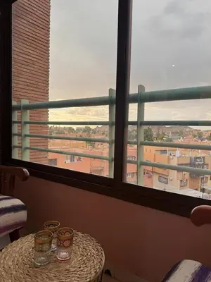 a table in a room with a large window at Appartement 2 Chambres 2 Balcons Gueliz in Marrakech